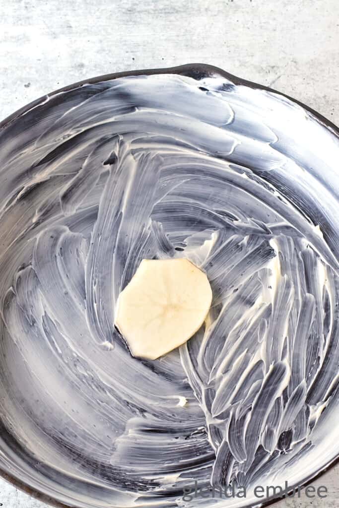 One thin slice of potato layed in the center of the bottom of a cast iron skillet that has been greased with butter